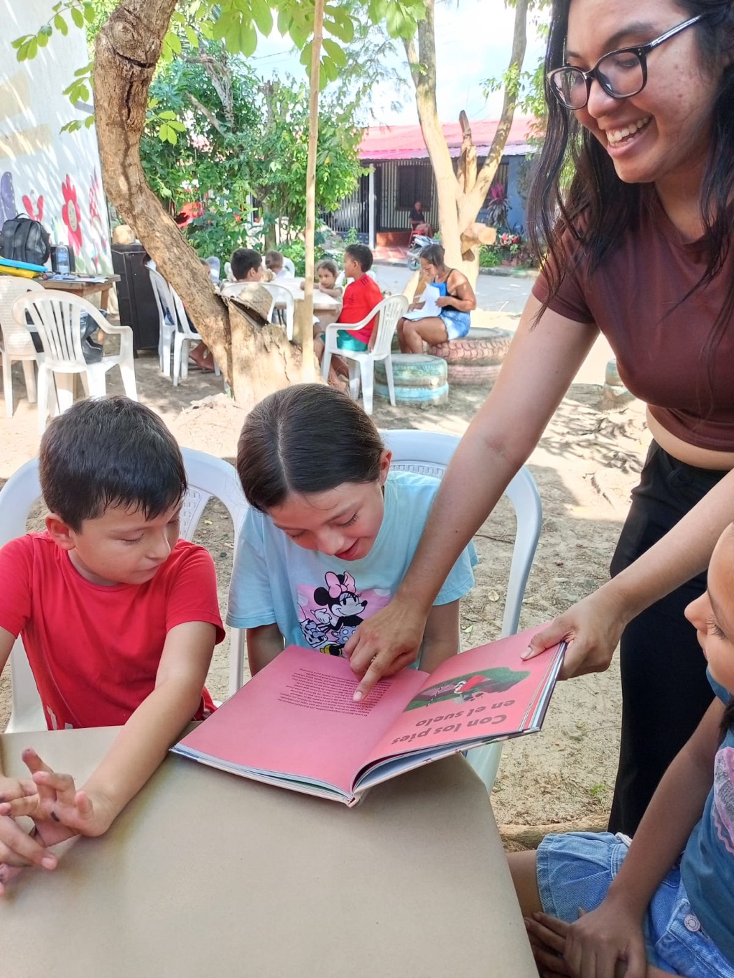 Niños leyendo un cuento junto a una tallerista de Createca